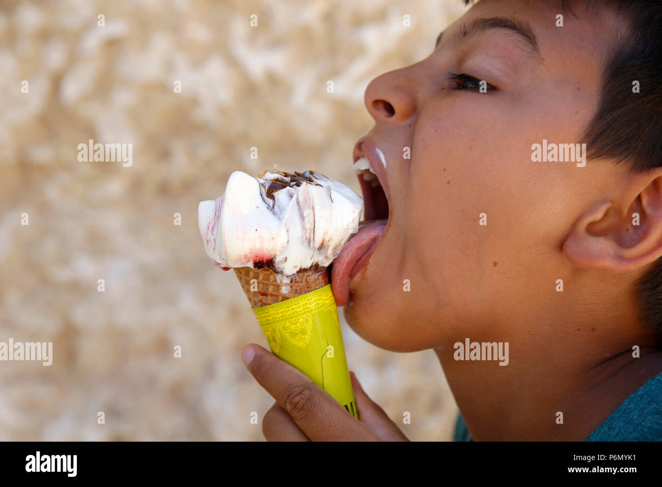 11-anno-vecchio ragazzo di mangiare un gelato nel Salento, Italia. Foto Stock