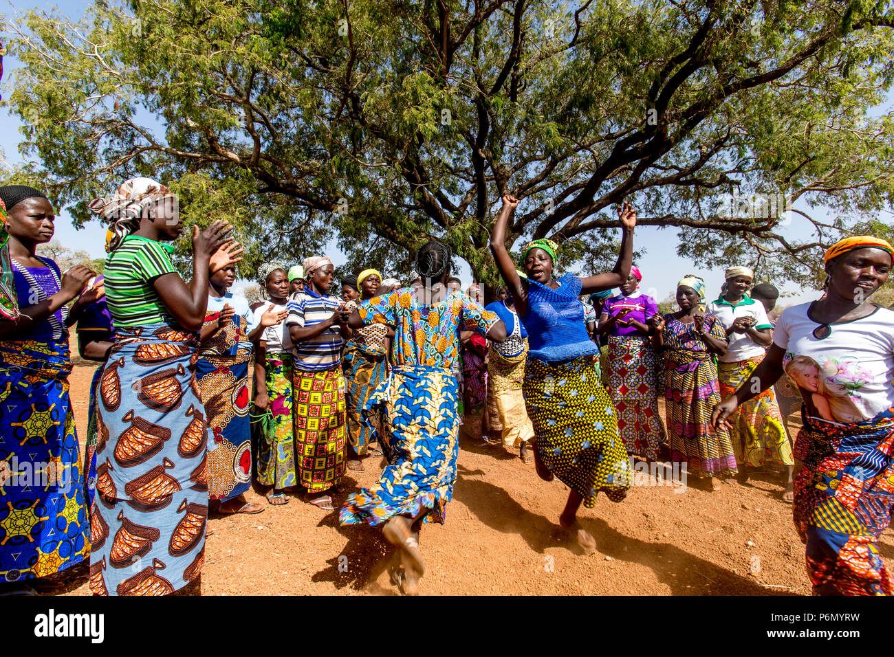I membri di una donna cooperativa di microfinanza accoglie il visitatore con le danze nel nord del Togo. Foto Stock