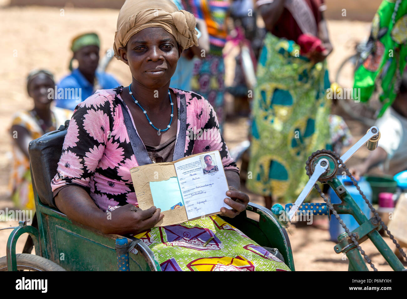 Disabilitato membro di una donna cooperativa di microfinanza che mostra il suo libretto di risparmio nel nord del Togo. Foto Stock