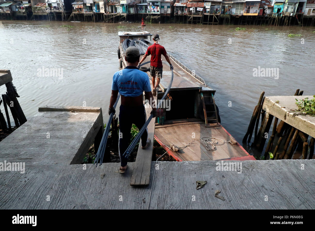 Mercato galleggiante lungo il fiume Mekong. Tondino in acciaio per cemento armato costruzione edilizia. Lavoratori edili. In Cai Be. Il Vietnam. Foto Stock