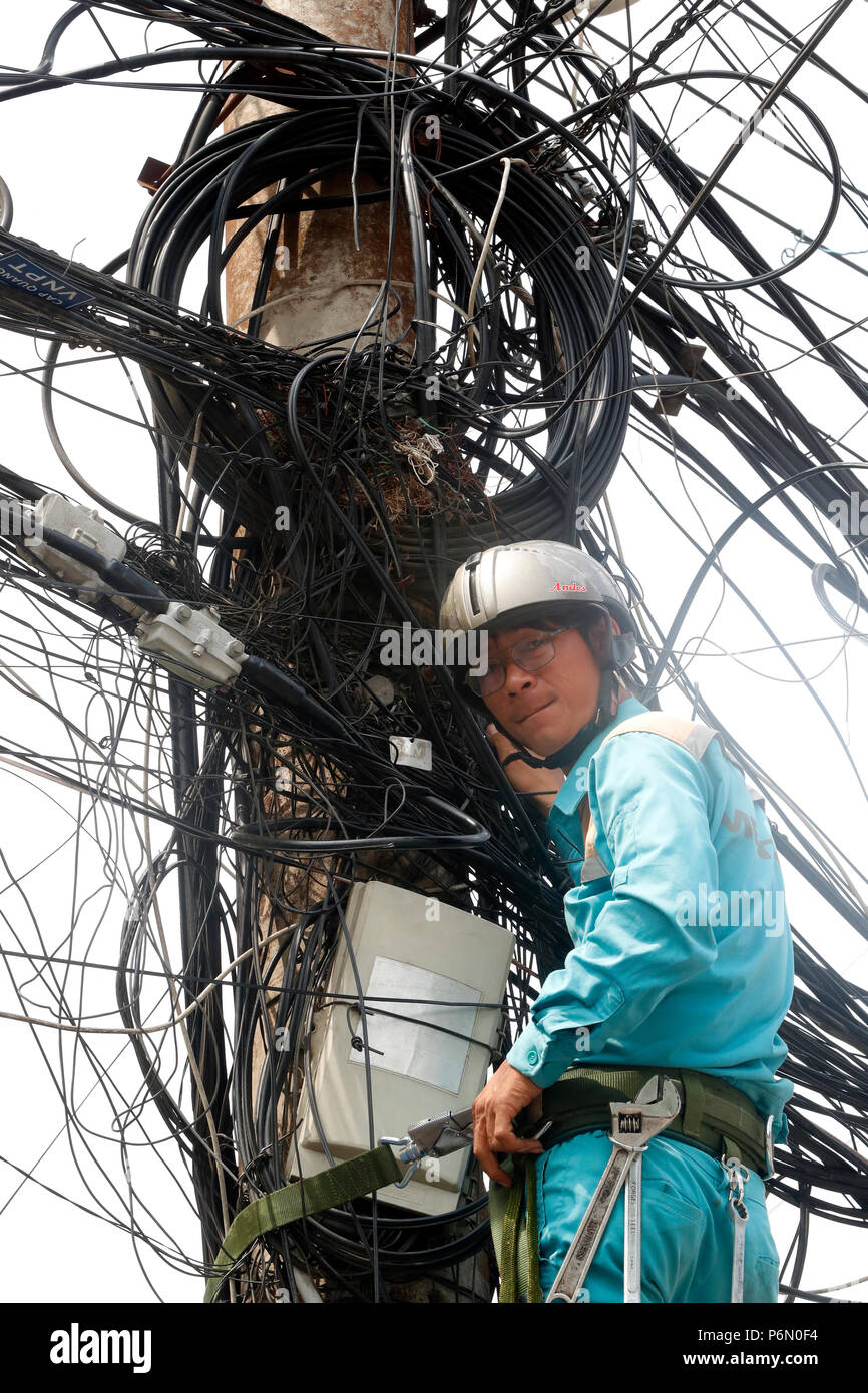 Elettricista di manutenzione riparazione elettricità pilone. In Cai Be. Il Vietnam. Foto Stock