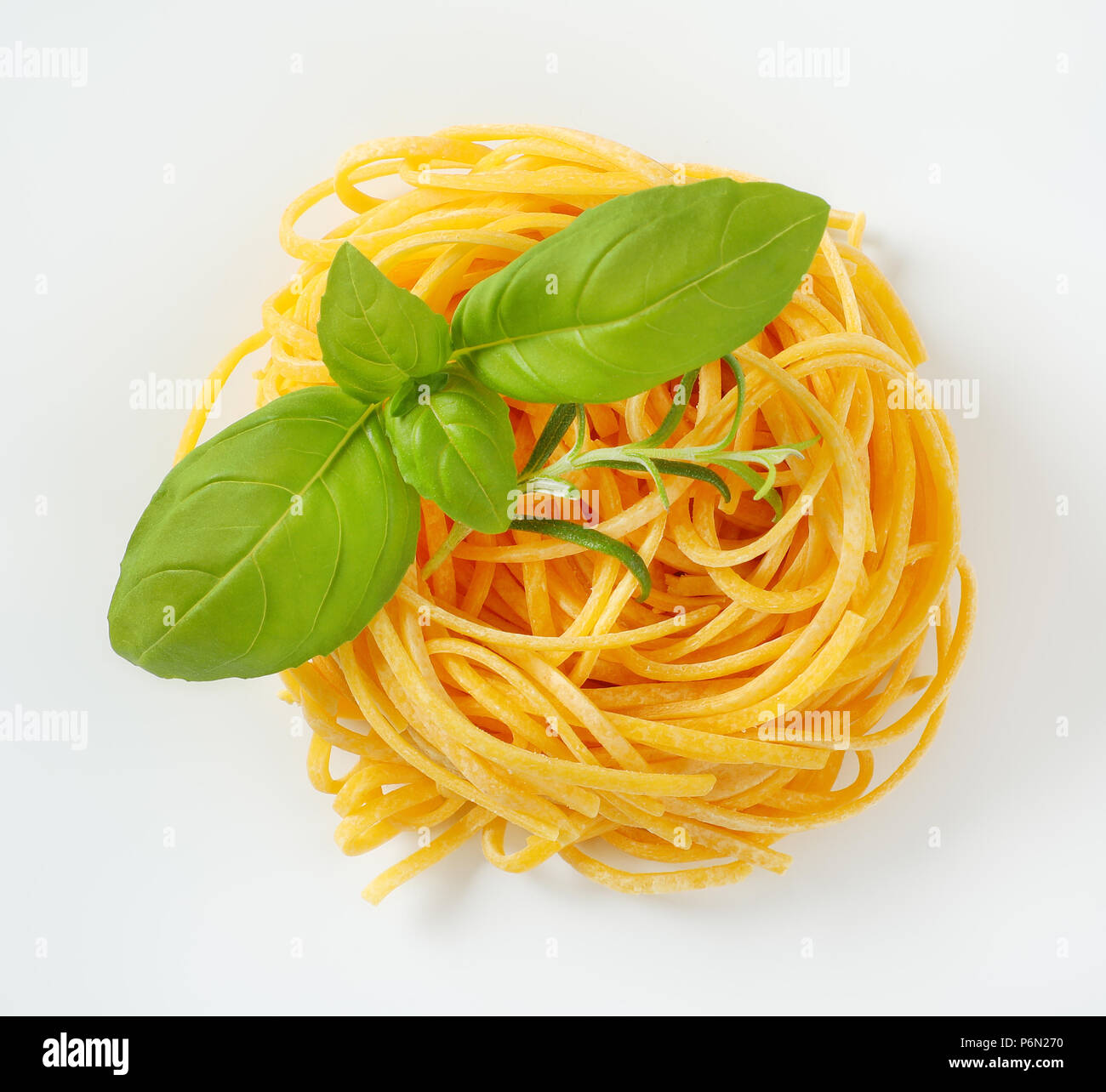 Bundle di spaghetti con erbe fresche su sfondo bianco Foto Stock