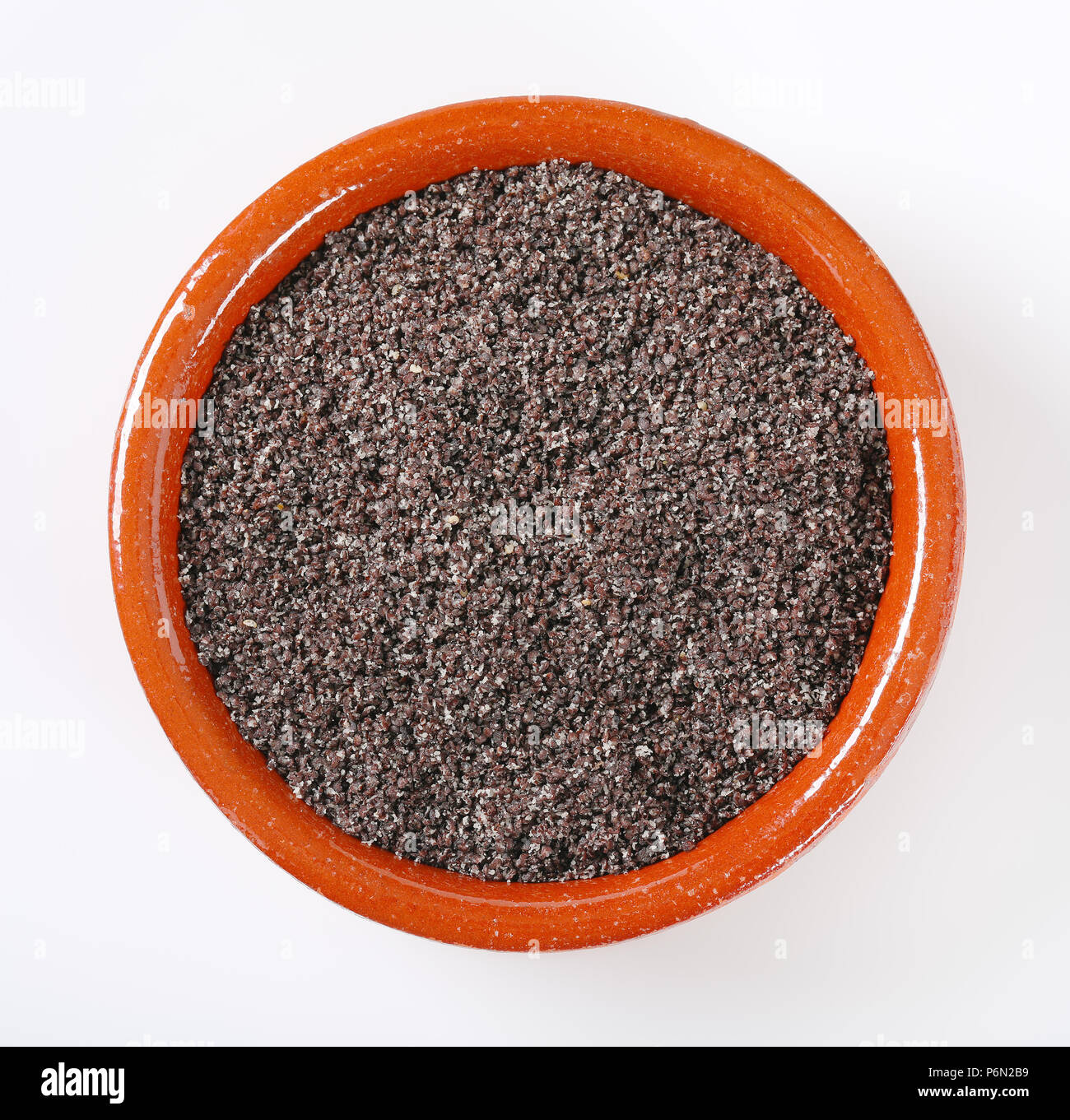 Ciotola di terra di semi di papavero su sfondo bianco Foto Stock
