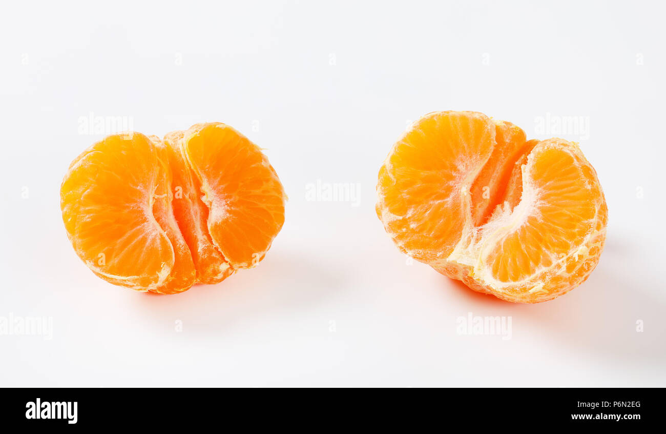 Dimezzato sbucciato tangerine su sfondo bianco Foto Stock