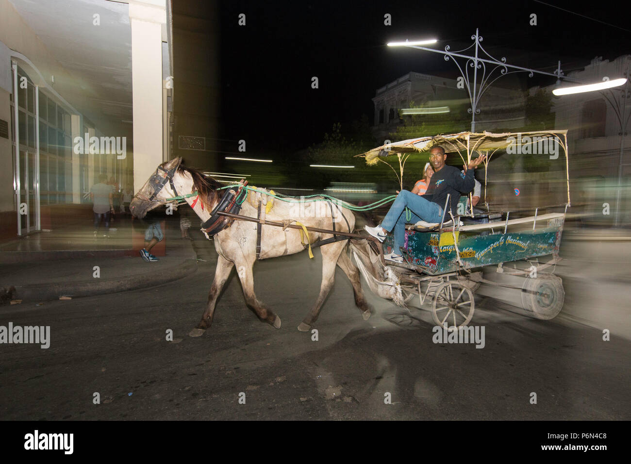 Una carrozza trainata da cavalli di notte noto localmente come un coche a Cienfuegos, Cuba. Foto Stock