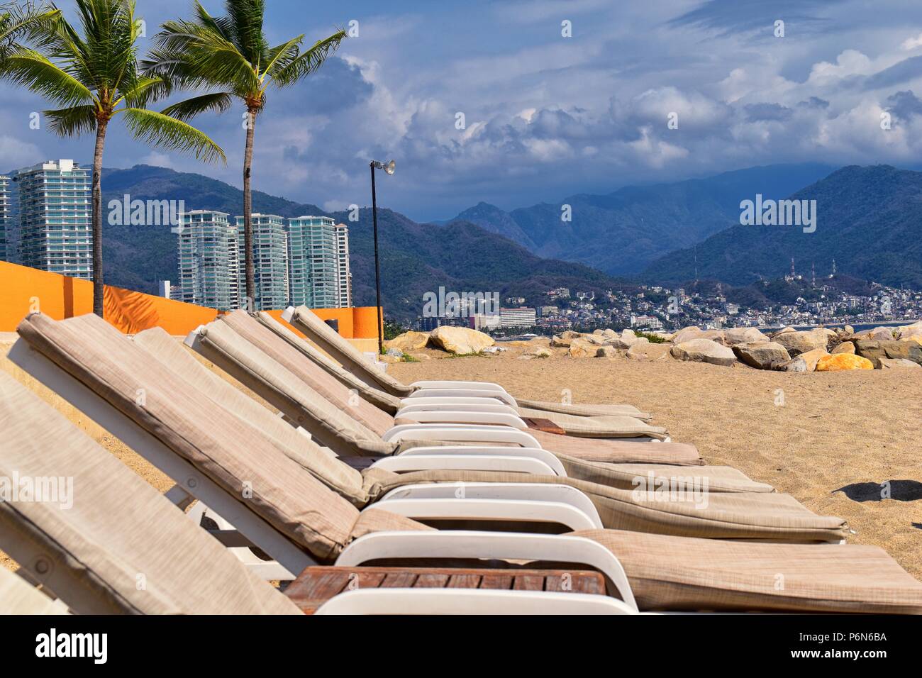 Sulla spiaggia, sulla città e vista oceano in Puerto Vallarta Messico con sedie a sdraio e a coste. Foto Stock