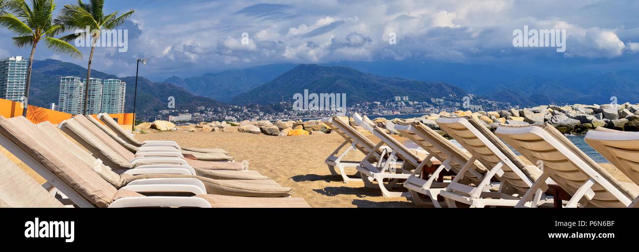Sulla spiaggia, sulla città e vista oceano in Puerto Vallarta Messico con sedie a sdraio e a coste. Foto Stock