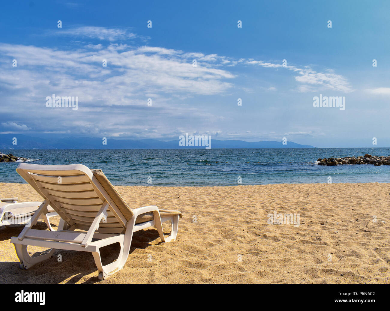 Sulla spiaggia, sulla città e vista oceano in Puerto Vallarta Messico con sedie a sdraio e a coste. Foto Stock
