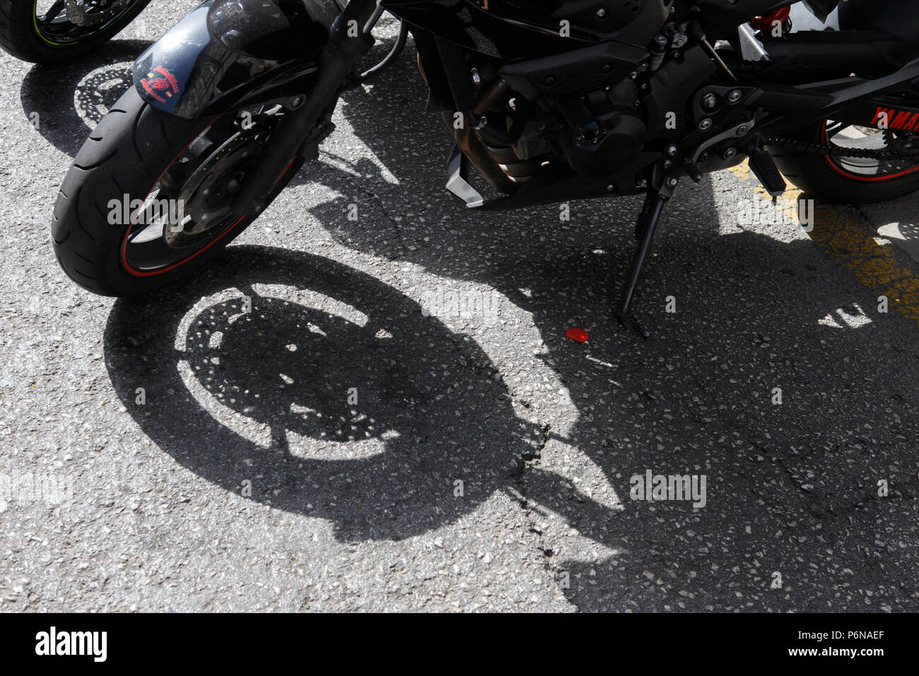 Ruota di moto e di ombra sulla terra street vicino, Foto Stock