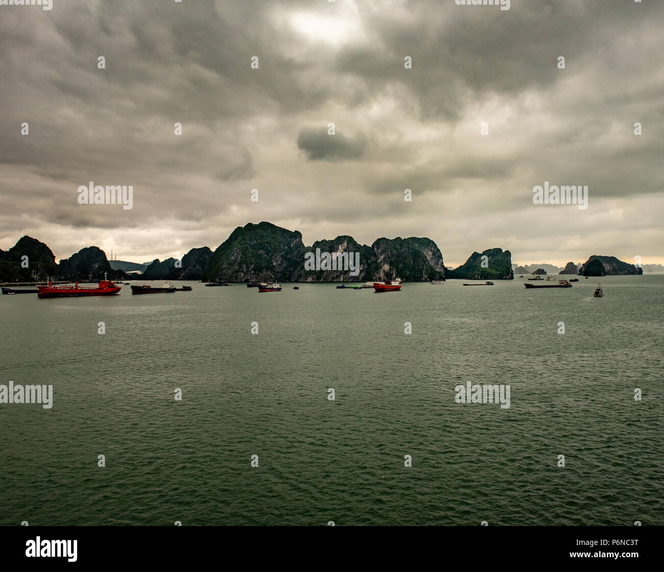 Barche in Halong Bay Harbor sotto un cielo minaccioso. Foto Stock