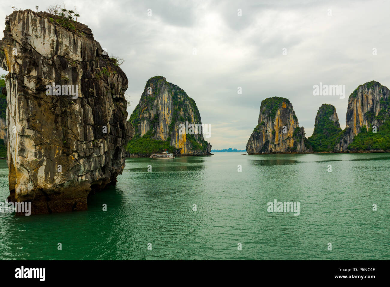 Spettacolari formazioni rocciose nella baia di Halong sotto cieli minacciosi. Foto Stock
