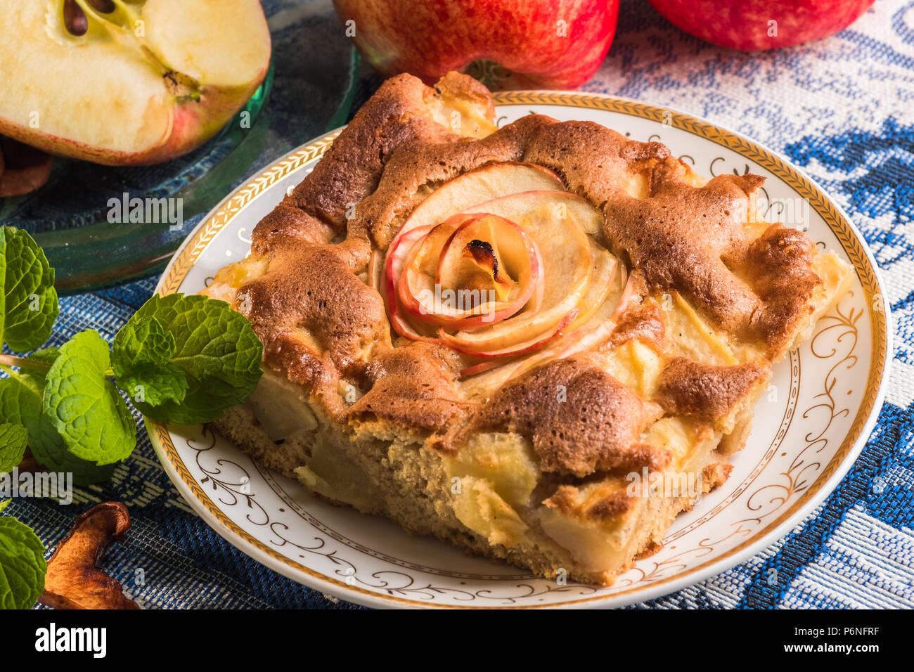 Delizioso caldo Torta di mele sulla piastra con mele fresche. Un pezzo di torta con fette di mela rossa in centro. Famosa crostata con diversi tipi di ricette. Foto Stock