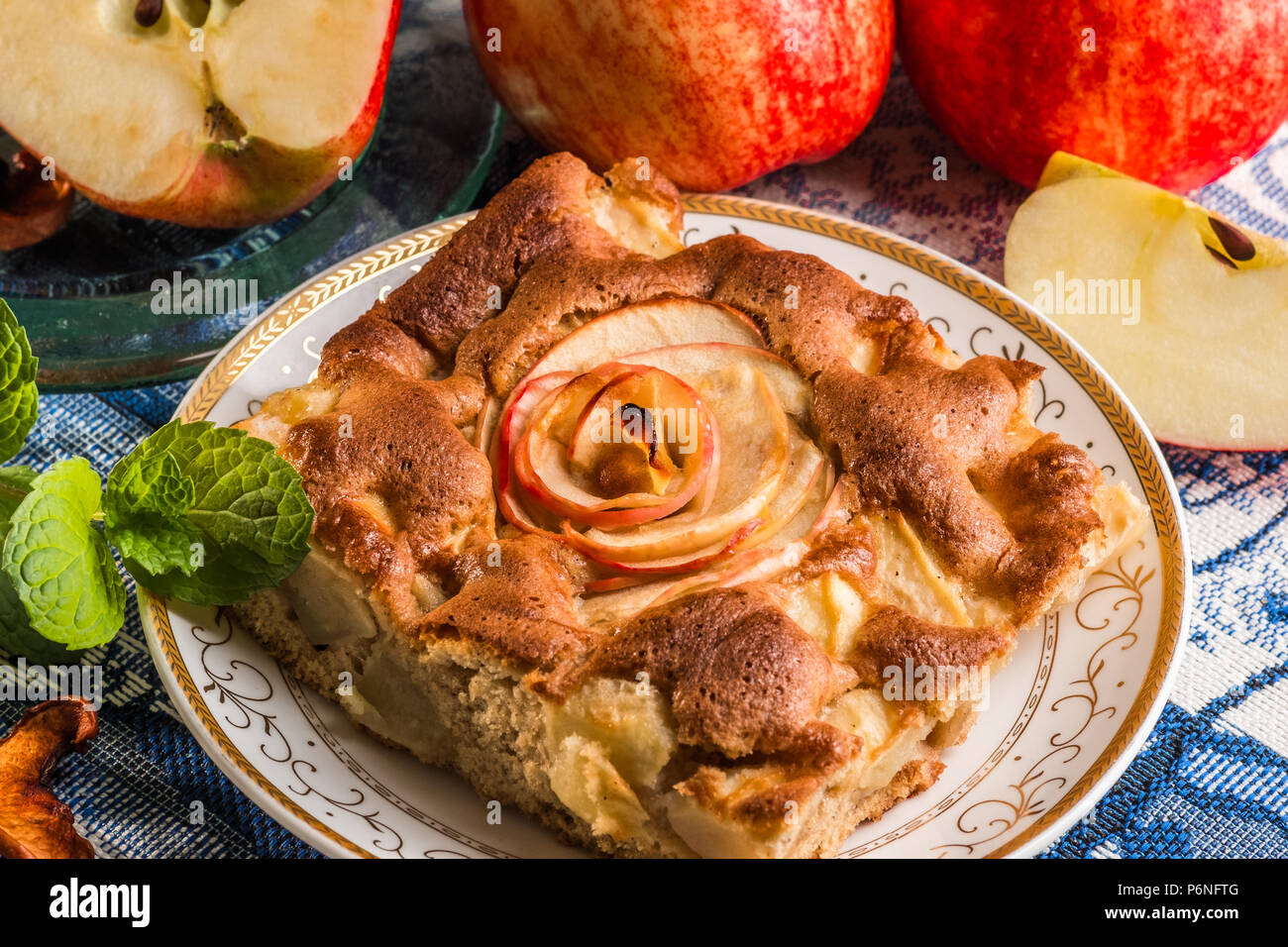 Delizioso caldo Torta di mele sulla piastra con mele fresche. Un pezzo di torta con fette di mela rossa in centro. Famosa crostata con diversi tipi di ricette. Foto Stock