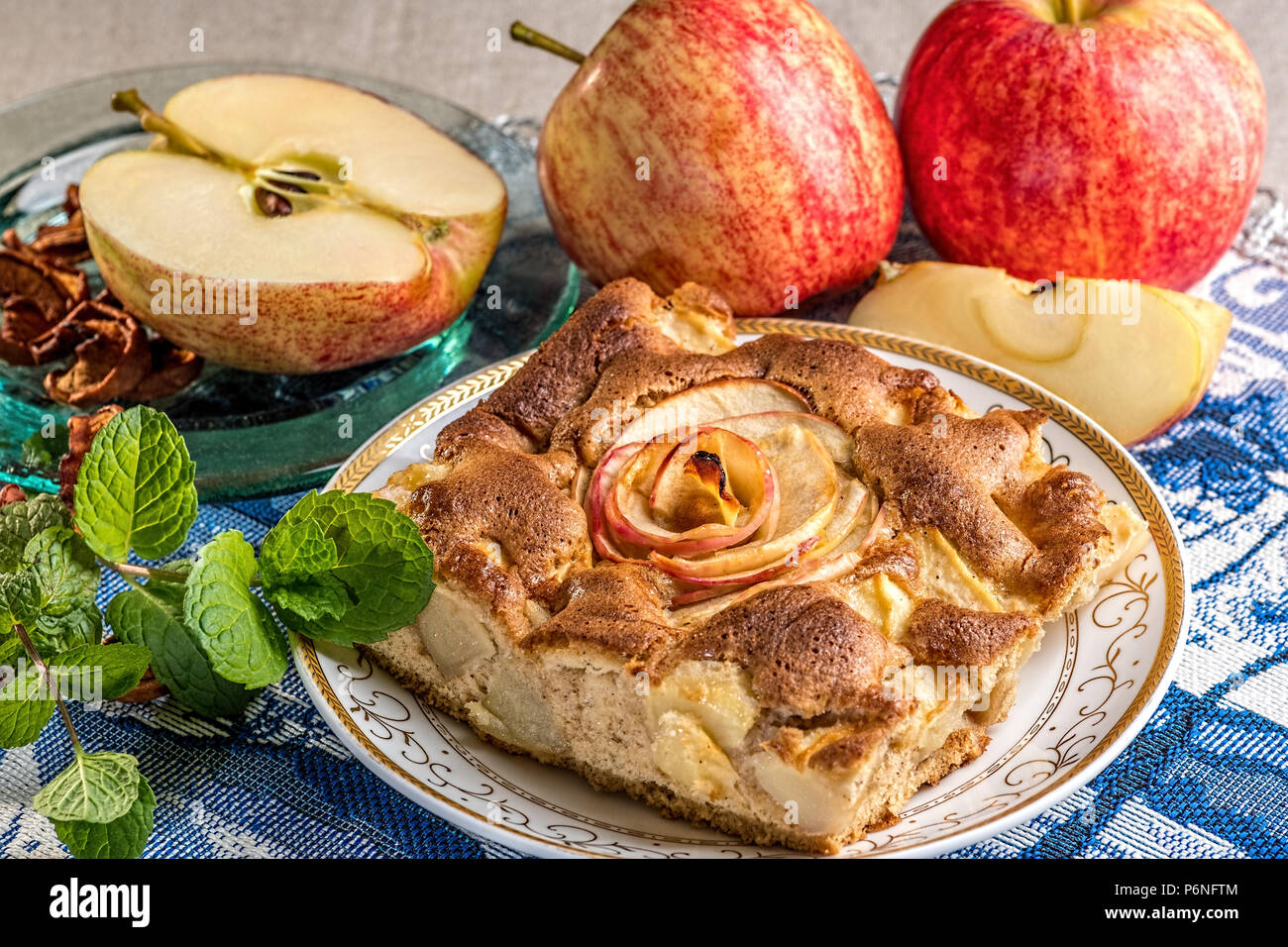 Delizioso caldo Torta di mele sulla piastra con mele fresche. Un pezzo di torta con fette di mela rossa in centro. Famosa crostata con diversi tipi di ricette. Foto Stock