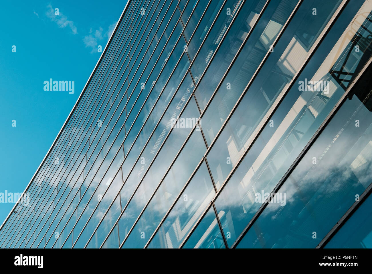 La facciata in vetro dell'ufficio moderno edificio e cielo blu Foto Stock