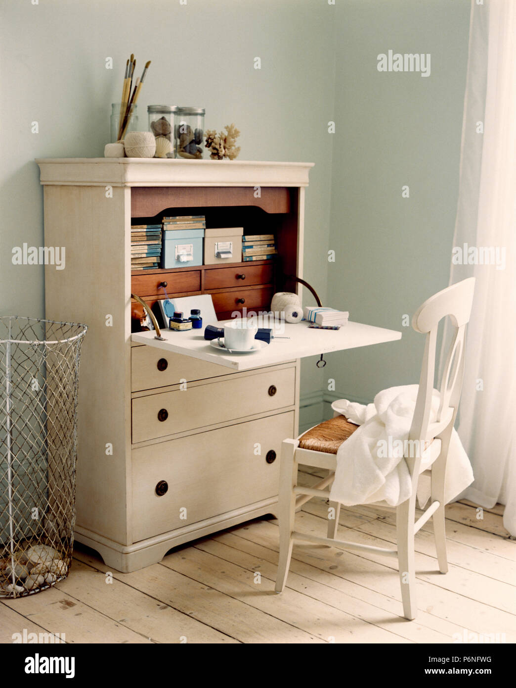 Sedia bianca alla scrivania, armadio con pull-down rivelando shelf di storage Foto Stock