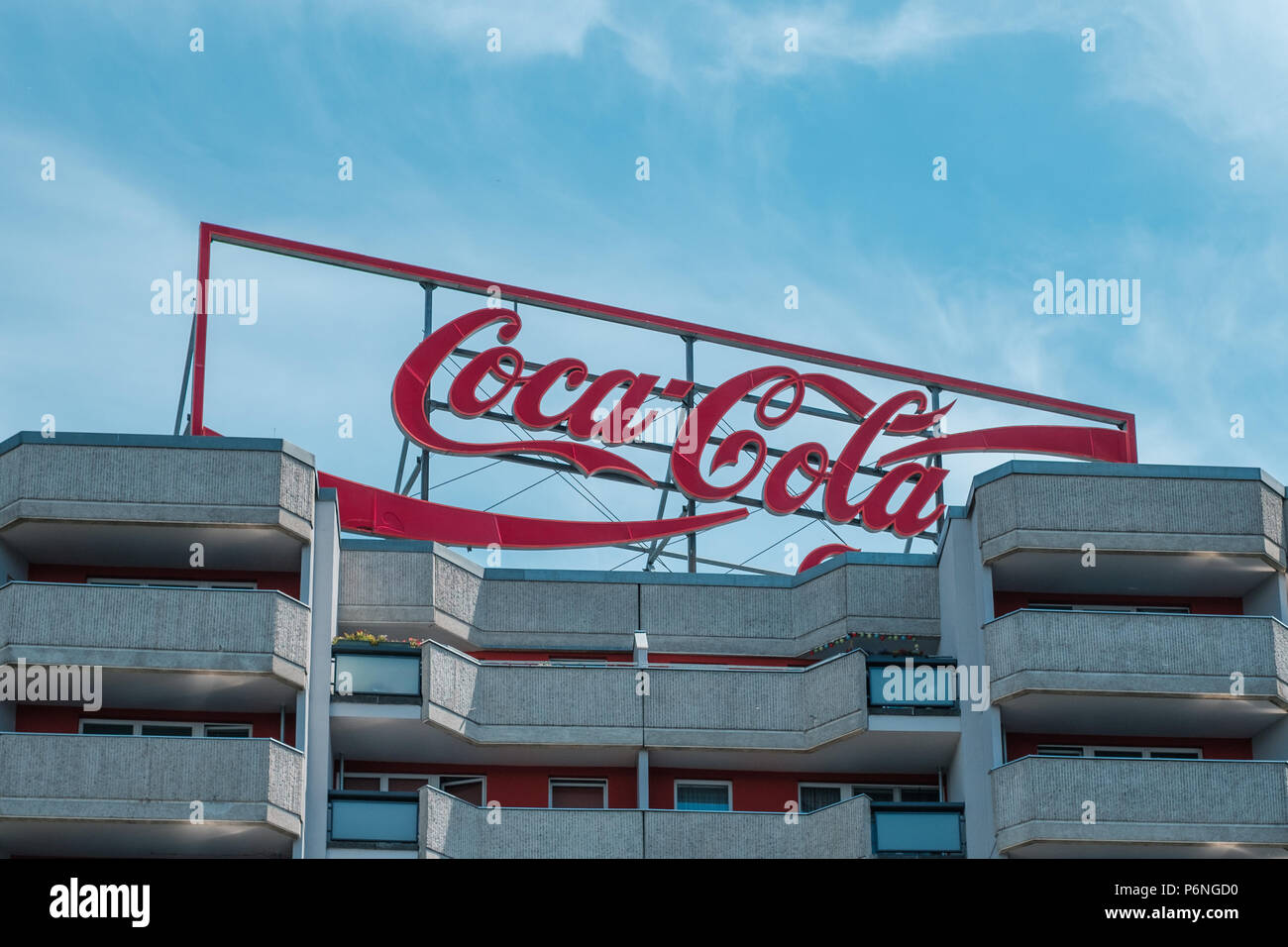Berlino, Germania - Giugno 2018: Il logo della Coca Cola pubblicità luce al neon lettere sul tetto edificio a Berlino, Germania Foto Stock