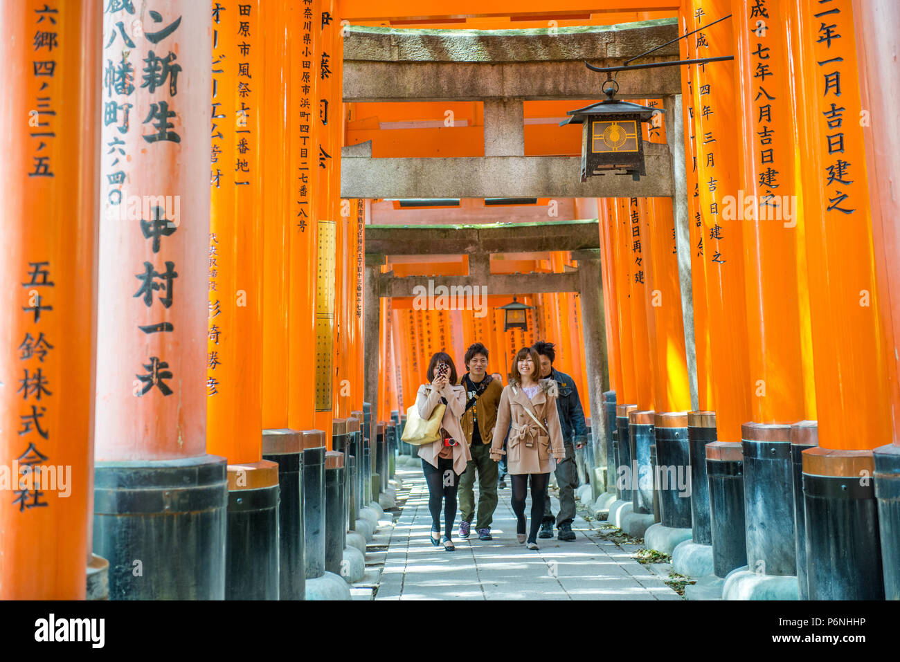 I turisti giapponesi esplorare Fushimi Inari Taisha a Kyoto, in Giappone. Lungo il percorso principale ci sono più di 10000 torii gates. Foto Stock