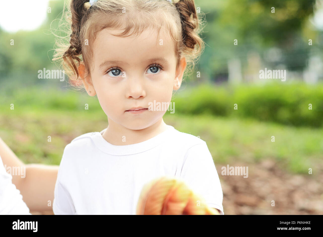 Close up ritratto di simpatici baby girl nel parco. Foto Stock