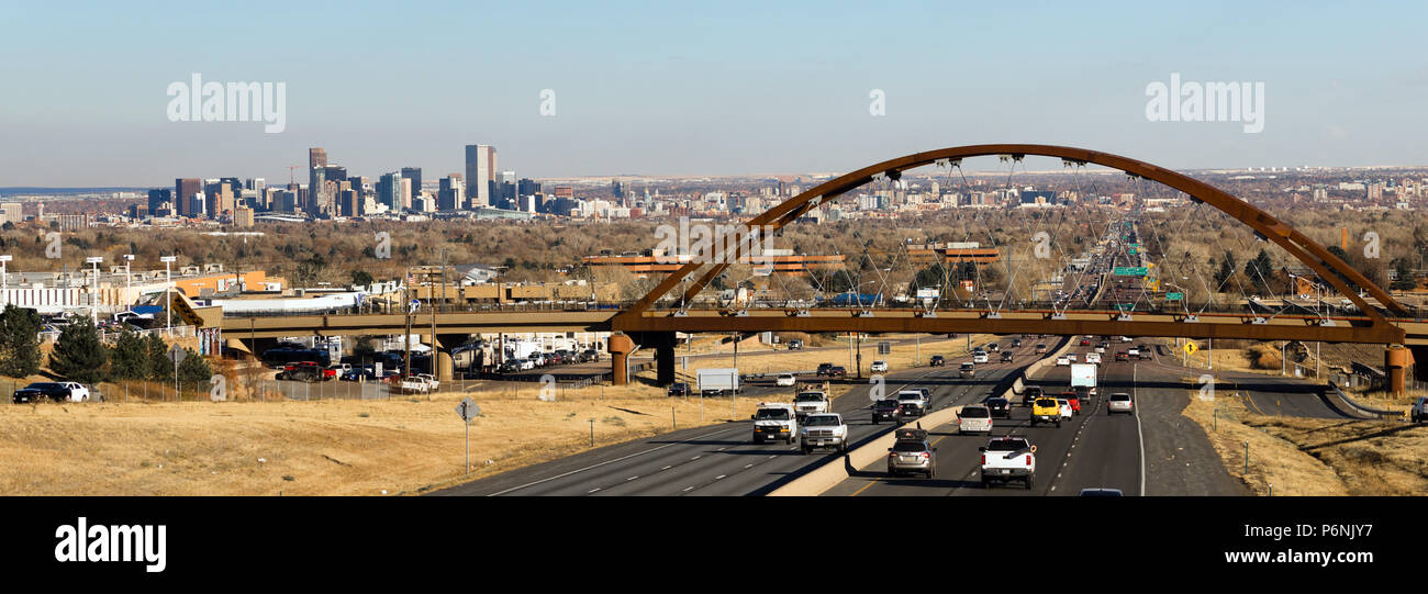 Il traffico automobilistico passa sotto un ponte che porta i treni per il trasporto pubblico in Denver area metropolitana Foto Stock