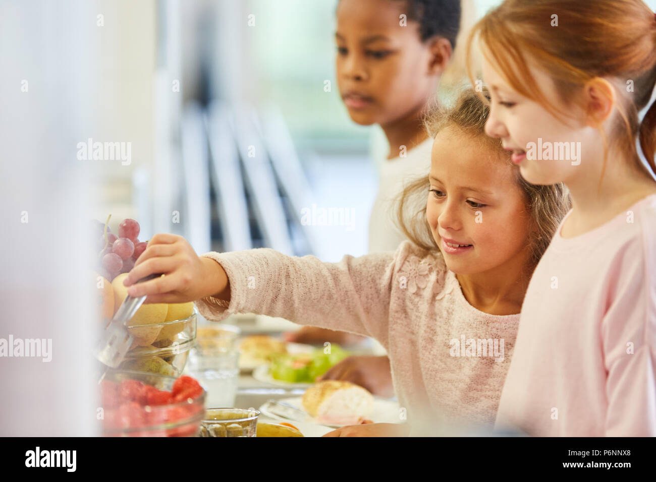 Bambini pick up food presso la caffetteria a buffet in asilo nido o alla scuola elementare Foto Stock