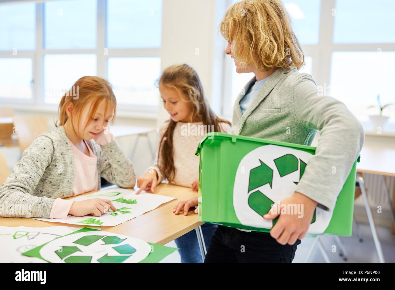 Gli studenti pianificare un progetto di riciclaggio nella scuola elementare come un team Foto Stock