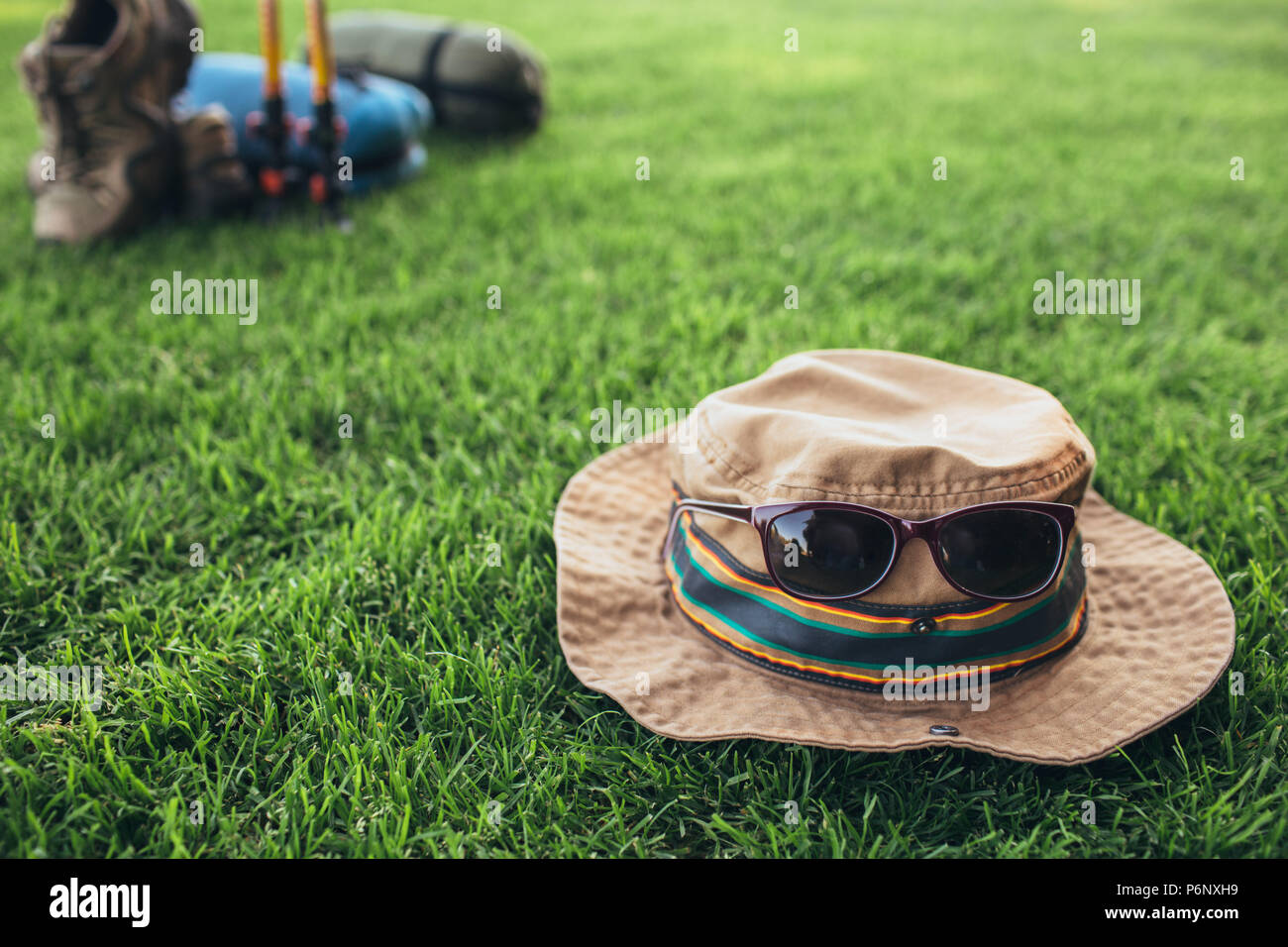 Hat di un viaggiatore con gli occhiali da sole sul prato Foto Stock