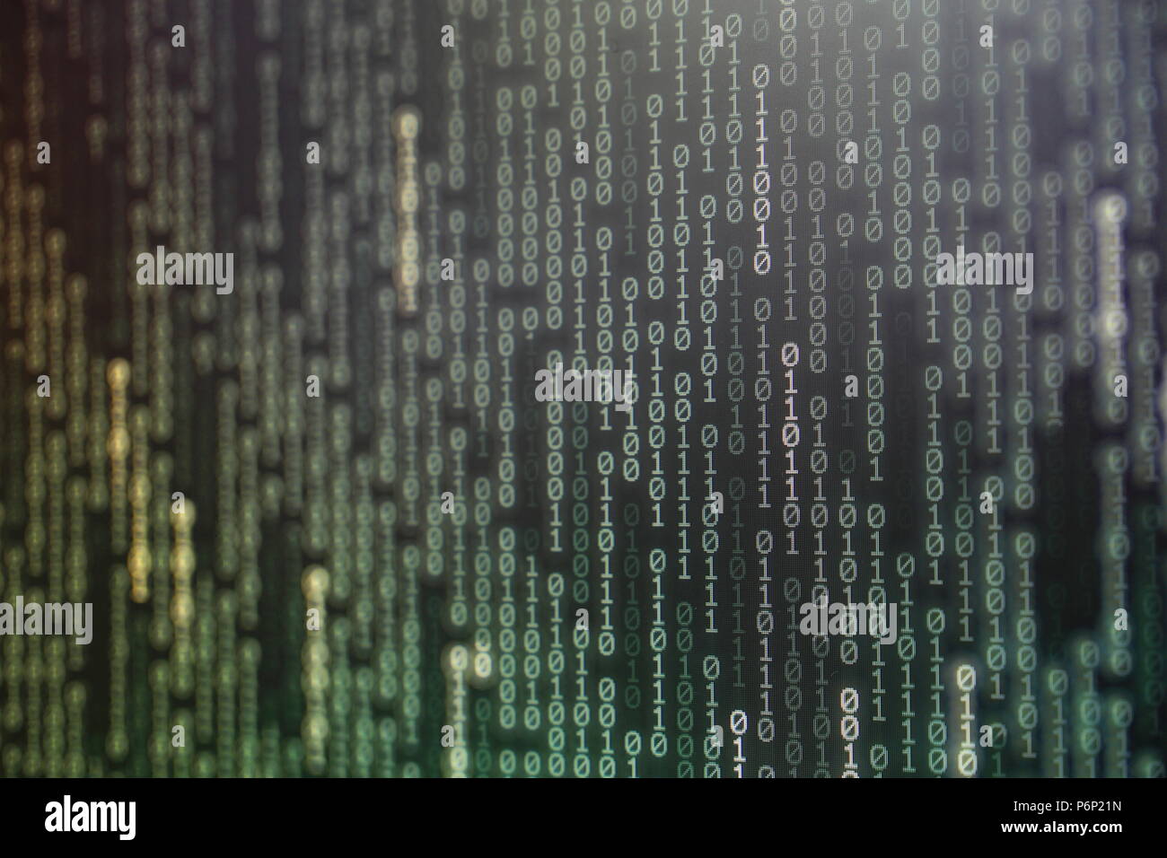 Potenza di dati di grandi dimensioni. codice binario bit di informazioni sul monitor del computer schermo. luce verde testo numero uno e zero. blur concentrato blu luce bokeh di fondo Foto Stock