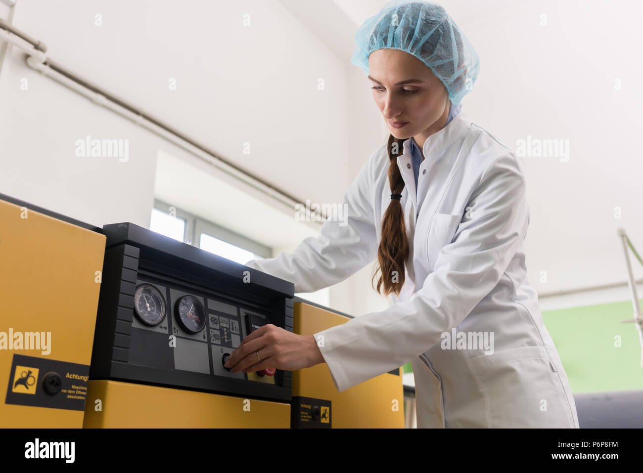 Donna ingegnere iscritto osservazioni sulle attrezzature e produzione Foto Stock