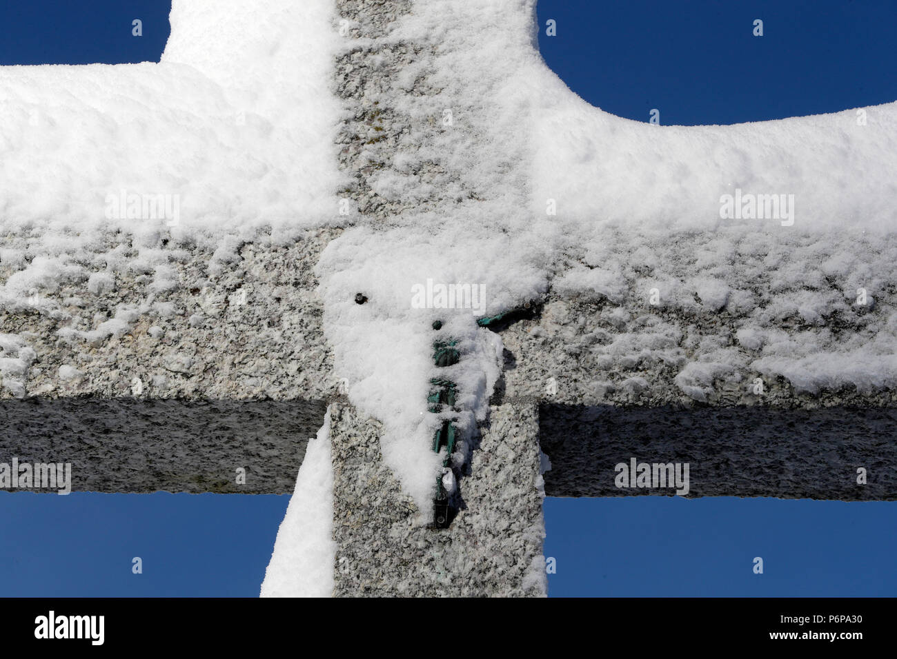 Croce di pietra con la neve in inverno. Megeve. La Francia. Foto Stock