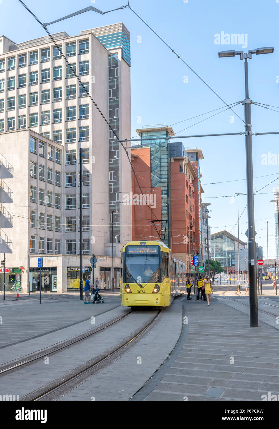 Tram Metrolink passando tra i blocchi degli uffici nel centro di Manchester, Regno Unito Foto Stock
