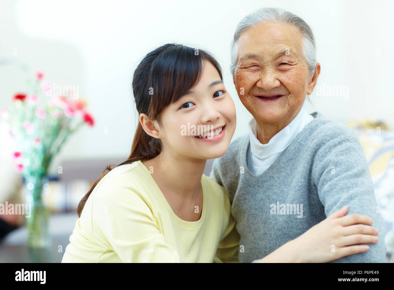 Giovane donna asiatica con sua nonna in casa Foto Stock
