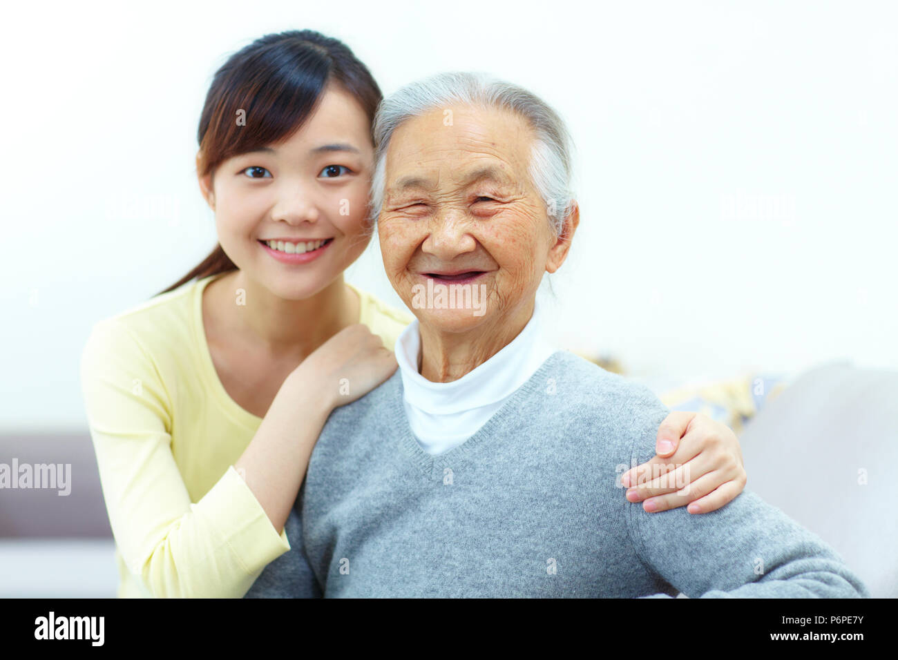 Giovane donna asiatica con sua nonna in casa Foto Stock