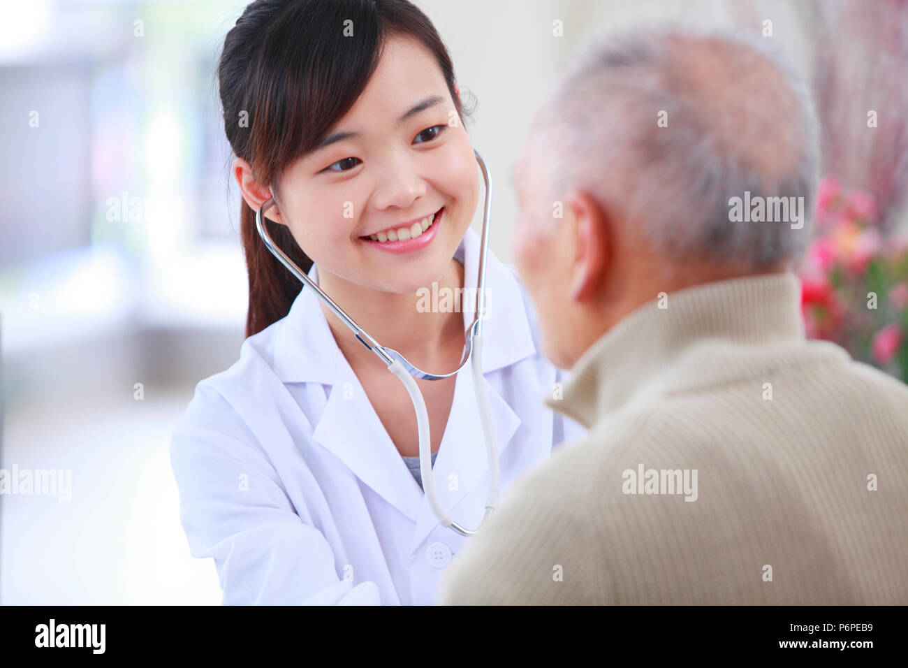 Giovani asiatici medico donna facendo medico di controllo sani ai senior uomo cinese Foto Stock
