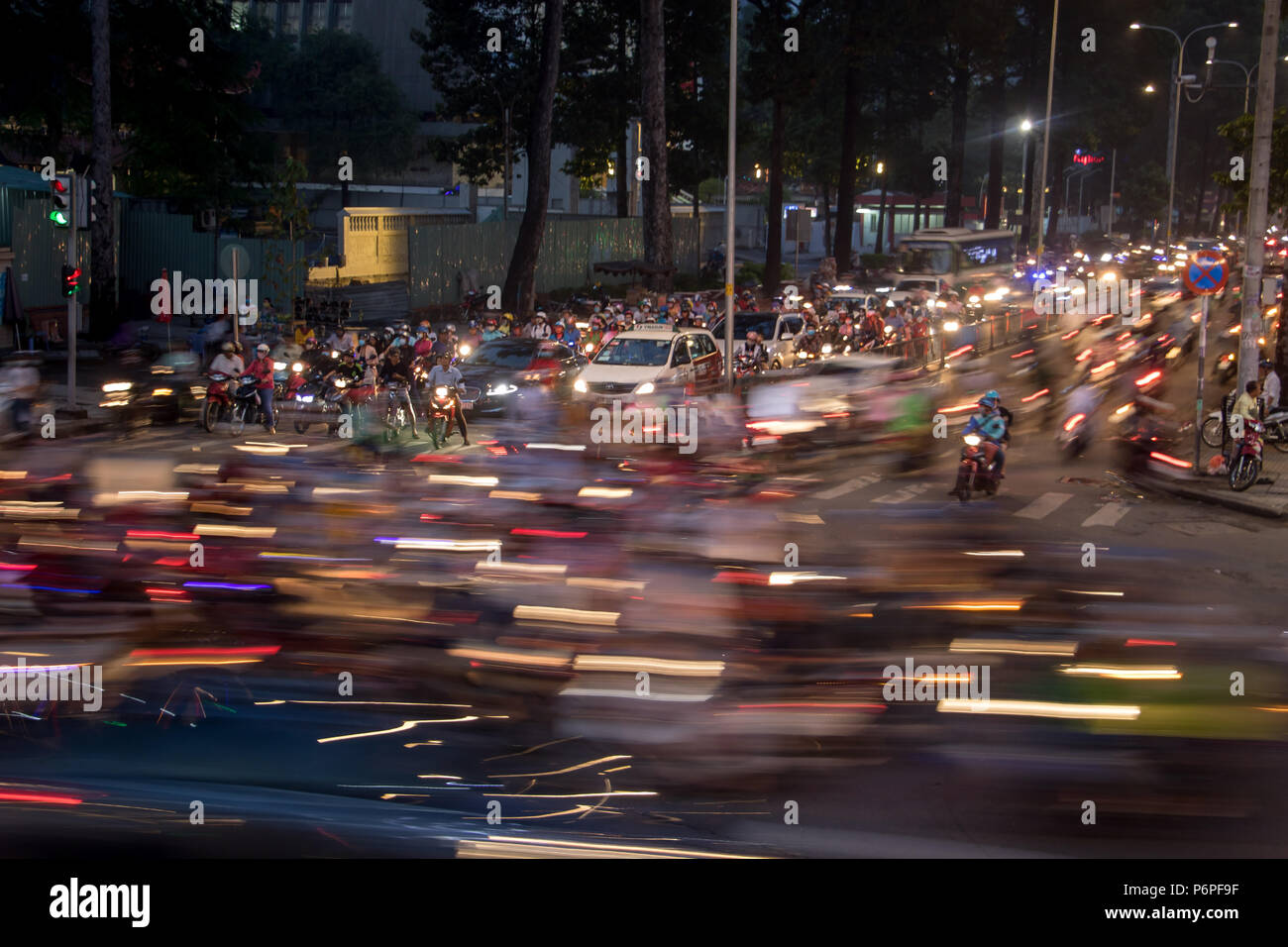 A Saigon, Vietnam, 14 dic 2017, alta densità di traffico di notte intersezione con luci sfocate passando per motocicli e veicoli. Foto Stock