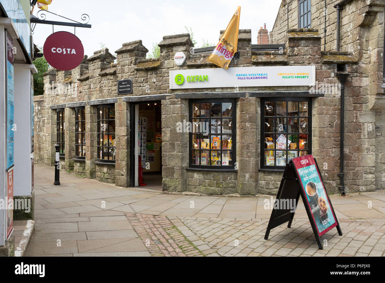 Un negozio di Oxfam nex di una Costa Coffee shop in Shaftesbury Nord Inghilterra Dorset Regno Unito GB Foto Stock