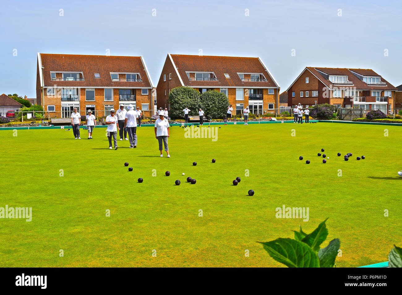 I giocatori godono di una tranquilla partita a bocce a Milford on Sea Bowls Club del sole estivo. Hampshire Foto Stock