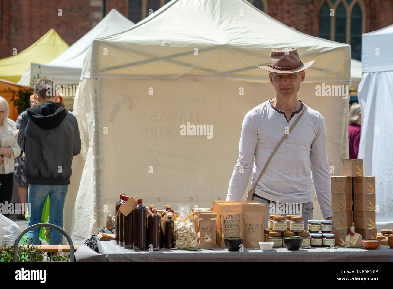 RIGA, Lettonia - 22 giugno 2018: solstizio d'estate mercato. Un uomo sta al mercato e vende vari prodotti dalla canapa indiana. Foto Stock