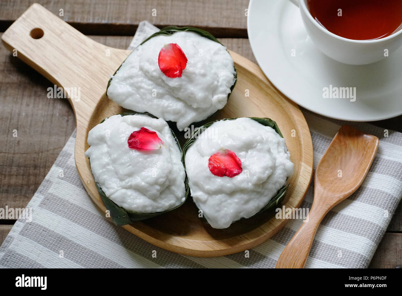 Budino tailandese con topping di noce di cocco sul piatto di legno Foto Stock