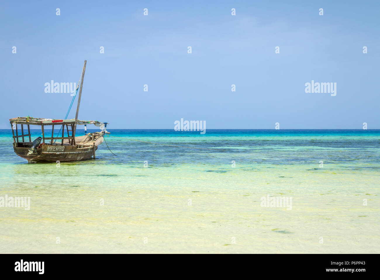 La pesca di Zanzibar dhow tradizionale barca a vela cordato con la bassa marea sulla costa di Zanzibar Foto Stock