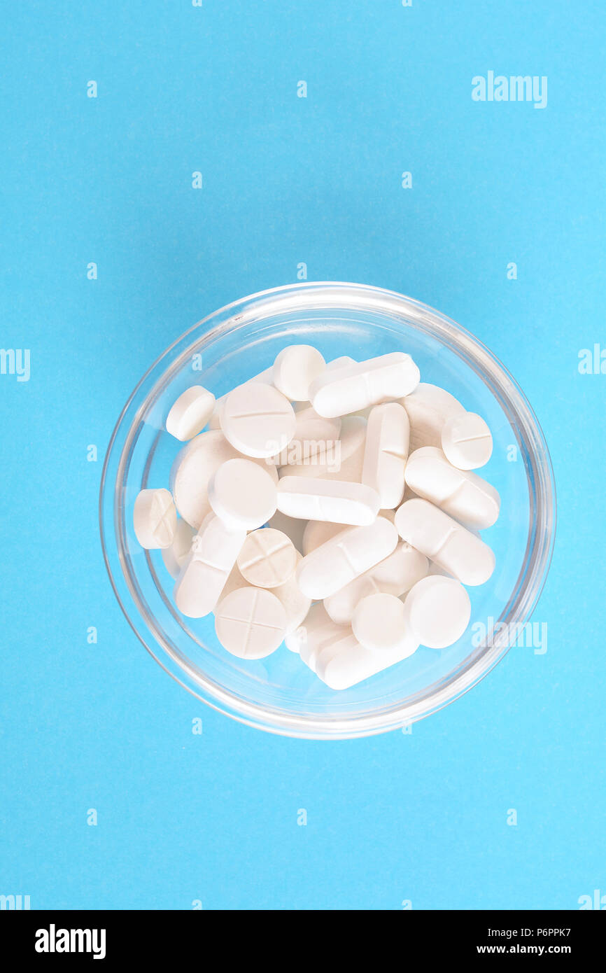 Vista superiore della pila di pillole di colore bianco su fondo azzurro. Il concetto di medicina Foto Stock