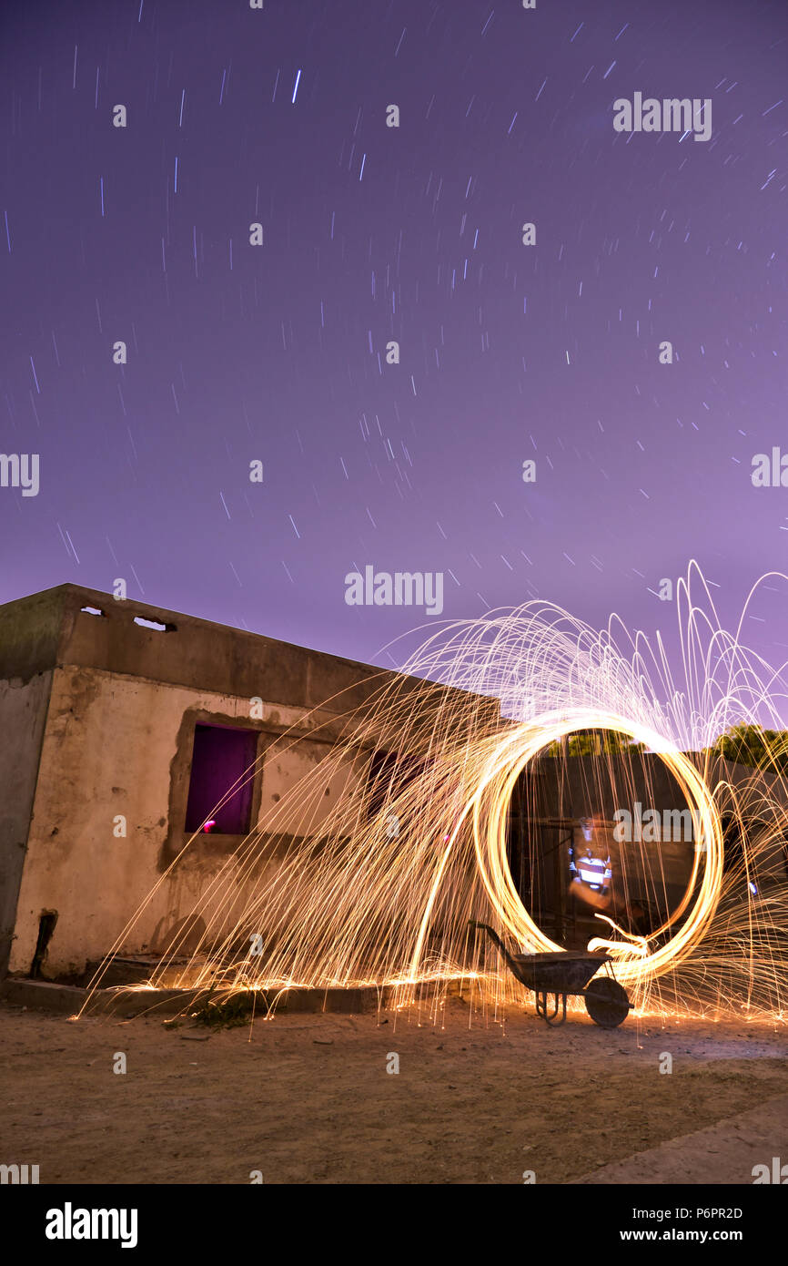 Notte di pittura con il fuoco e con i sentieri delle stelle in un edificio in costruzione. Foto Stock