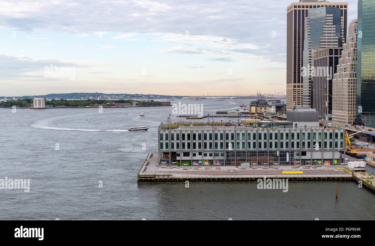 La città di New York / STATI UNITI D'America - 20 GIU 2018: East River con Pier e Governors Island al mattino presto nella città di New York Foto Stock