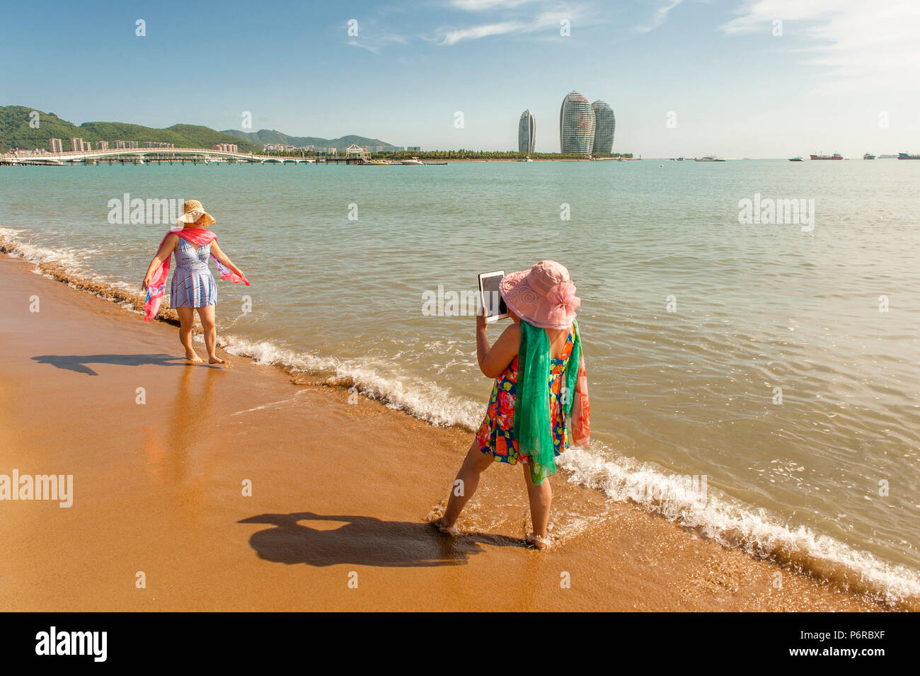 Due onorevoli a Riva del Sanyawan, la spiaggia della baia di Sanya, scattare foto. Foto Stock