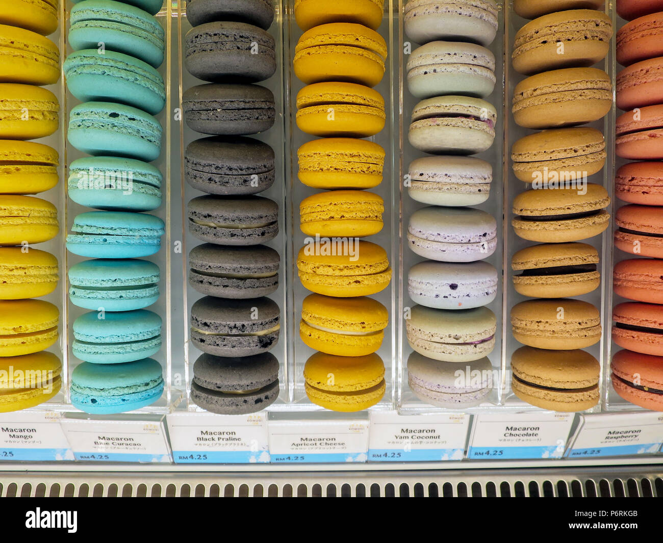 Righe di aromatizzato macarons francese per la vendita in una panetteria giapponese nel sud-est asiatico. Foto Stock
