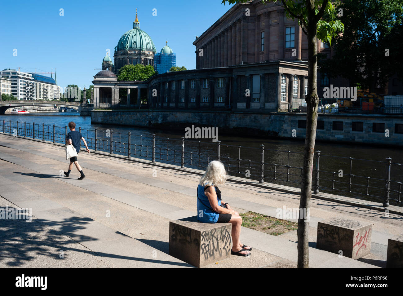 07.06.2018, Berlino, Germania, Europa - Una donna siede sulla riva del fiume Spree in berlinese di Mitte località. Foto Stock