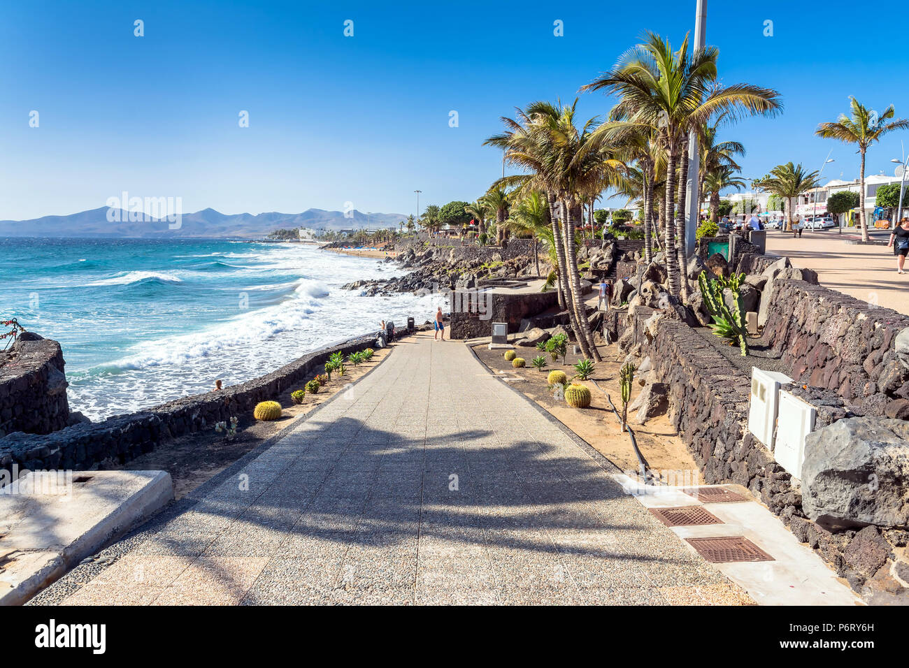 Puerto del Carmen, Spagna - 29 dicembre 2016: visualizzazione giorno del lungomare con palme e Spiaggia di Puerto del Carmen in Spagna. Puerto del Carmen è il principale a Foto Stock