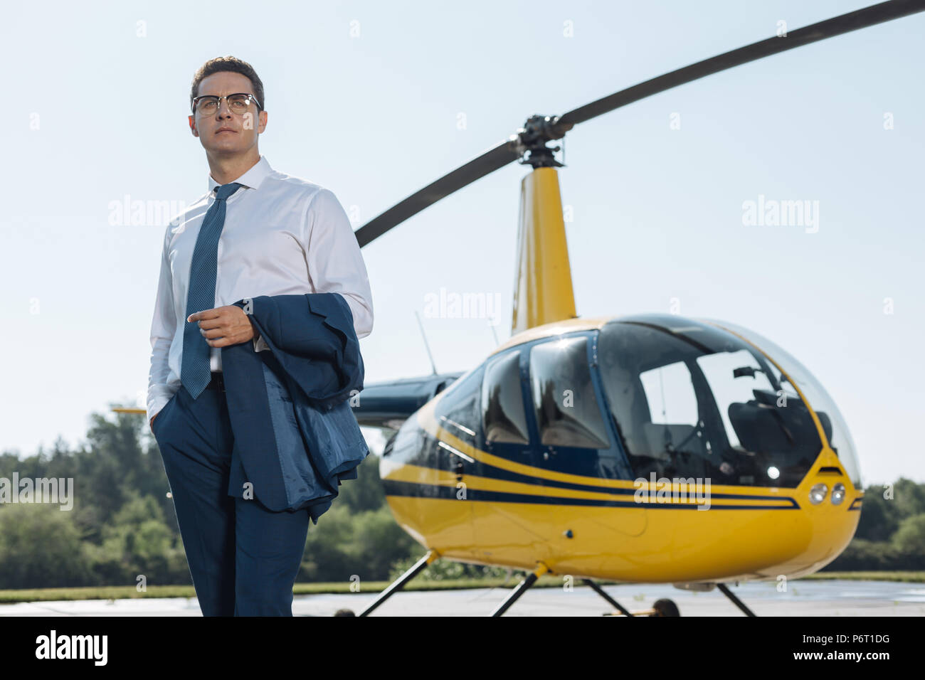 Affascinante giovane imprenditore in posa ad una Elisuperficie Foto Stock