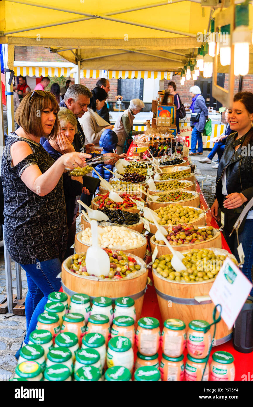 Olive, in piccole botti di rovere, essendo venduto sul mercato in stallo durante il sandwich della città di Le Weekend festival francese. Donna, 40s, indicando alcuni prima di acquistare. Foto Stock