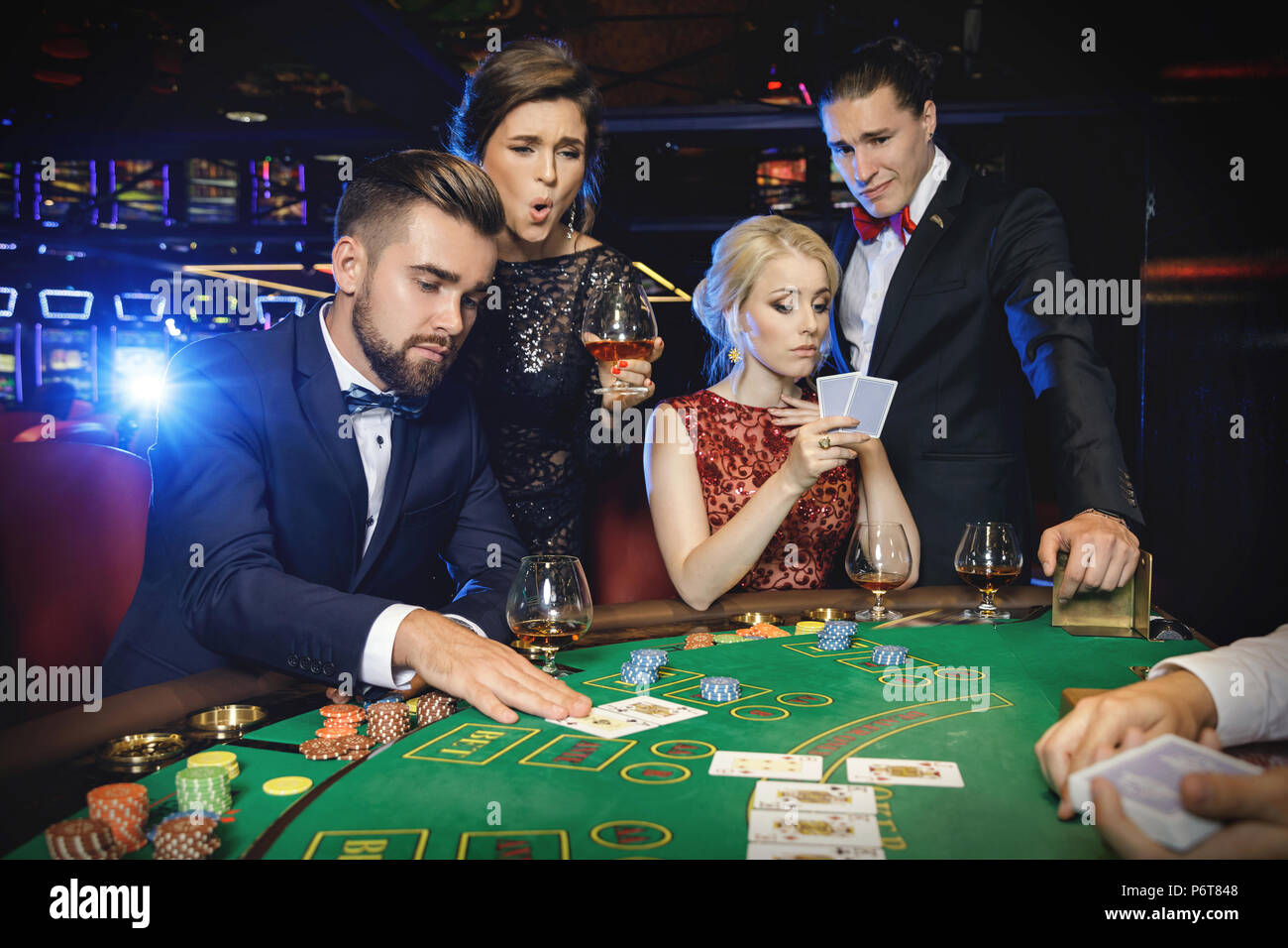 Vinti e vincitori. Gruppo di ricchi ben vestito la gente sta giocando a poker al casinò. Concetti di vita di lusso Foto Stock